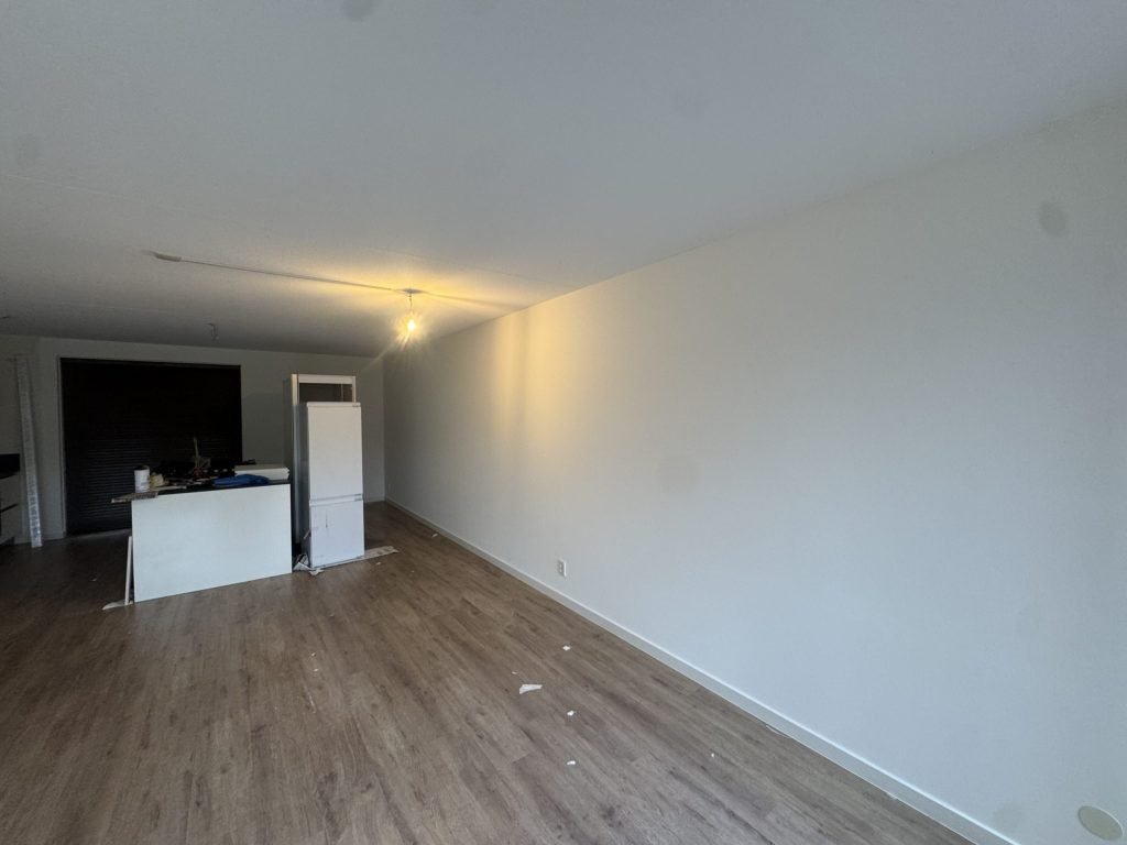 Lange woonkamerwand in wit renovlies, klaar voor de oplevering